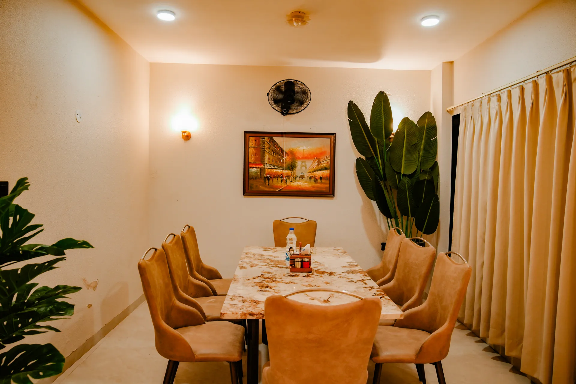 Amber dining space with a long table and upholstered chairs